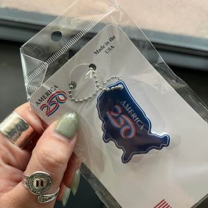 Hand Holding Patriotic Keychain In Packaging